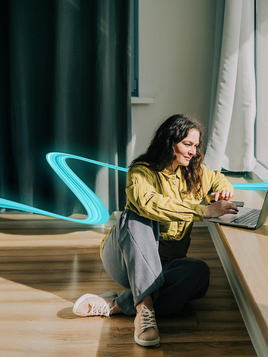 Woman sitting on a hardwood floor with a coffee mug in her hand.